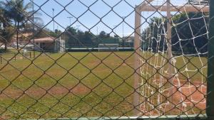 a view of a baseball field through a chain link fence at Apartamento no Jardim botânico in Brasilia