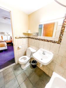 a bathroom with a toilet and a sink at Utica Rest Inn in Utica
