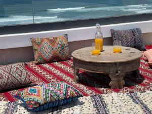 zwei Gläser Orangensaft auf einem Tisch mit Kissen in der Unterkunft Hawaii piscine-pool in Kenitra