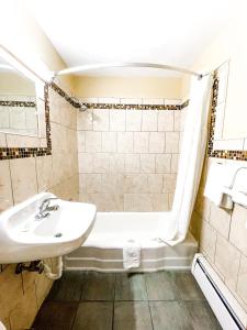 Utica Rest Inn في أوتيكا: حمام مع حوض وحوض استحمام