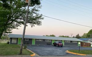 Diamond Motel - Abilene في Abilene: مبنى فيه سيارة متوقفة في موقف للسيارات