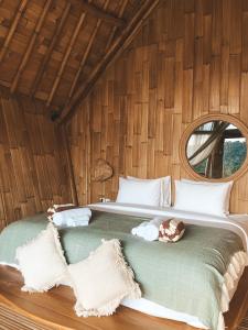 ein Schlafzimmer mit einem großen Bett an einer Holzwand in der Unterkunft Kalma Bamboo Eco Lodge in Kuta Lombok