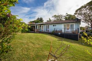 a house with a large yard in front of it at WindanSea Cottage Pet Friendly Ocean Glimpses in Vincentia