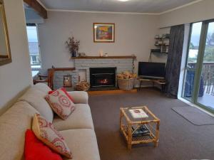 a living room with a couch and a fireplace at Lake Rotoiti Lakehouse Retreat in Rotorua