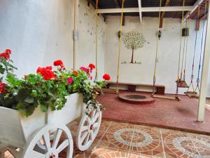 um quarto com flores vermelhas e um carrinho de mão com flores em El paraíso de Zacatlán DEPARTAMENTO con JARDÍN, 11 pax em Zacatlán