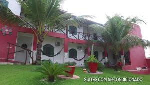 a building with palm trees in front of it at Pousada da Teteia in Praia Sêca