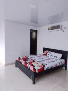 ein Schlafzimmer mit einem Bett in einem Zimmer in der Unterkunft Hostal Apartamentos Delgado in Florencia
