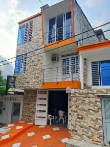 ein Haus mit orangefarbenem Teppich davor in der Unterkunft Hostal Apartamentos Delgado in Florencia