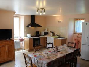 Gîte Tourtoirac, 4 pièces, 6 personnes - FR-1-616-8 في Tourtoirac: مطبخ مع طاولة ومطبخ مع ثلاجة بيضاء