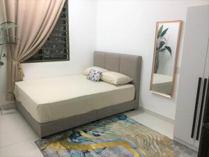 Cama en habitación con espejo y alfombra en CASA ADELIA GUESTHOUSE BALOK PERDANA GEBENG en Kampung Saberang Balok