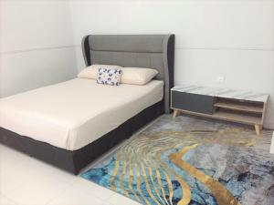 a small bedroom with a bed and a table at CASA ADELIA GUESTHOUSE BALOK PERDANA GEBENG in Kampung Saberang Balok