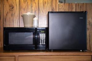 a microwave sitting on top of a wooden table at ARTOS MOTEL in Harvey