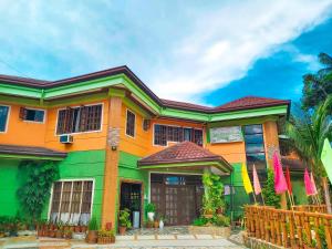 una casa colorida con una valla delante en Stefanie Grace Inn, en Loboc