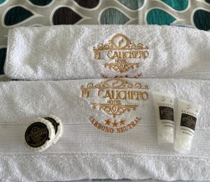 two rolls of white towels with two toothbrushes and two cups at El Cauchero Hotel Iquitos in Iquitos