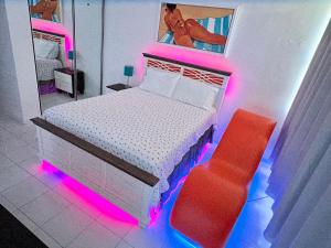 - une chambre avec un lit et une chaise rouge dans l'établissement Hobie Oceanfront apartment at Isla Verde, à San Juan