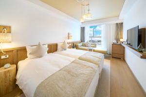 a hotel room with a large bed and a television at Hotel Resol Trinity Naha in Naha