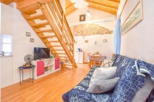 salon z kanapą i schodami w obiekcie Apartment Fjaka w mieście Žman