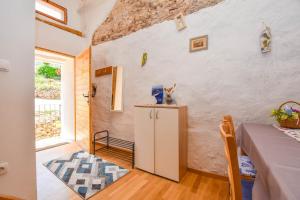 kuchnia i jadalnia ze stołem i oknem w obiekcie Apartment Fjaka w mieście Žman