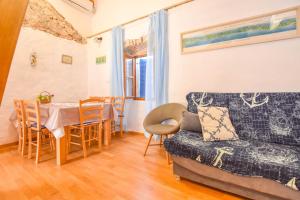 salon z kanapą i stołem w obiekcie Apartment Fjaka w mieście Žman