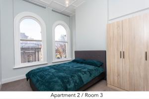 a bedroom with a bed and two windows at nap nap - Second floor in Dunedin