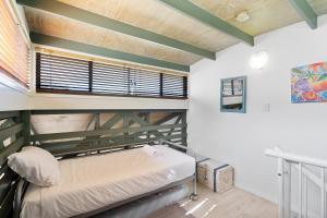 Ce lit superposé se trouve dans un dortoir doté d'une fenêtre. dans l'établissement MAIN STAY - 100m to patrolled beach, pool, wifi, close to cafes, à Point Lookout 10 autres photos