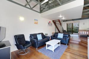 un salon avec deux chaises et une table dans l'établissement MAIN STAY - 100m to patrolled beach, pool, wifi, close to cafes, à Point Lookout