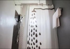 a shower with a white shower curtain with a black and white at Bella Ciao in Jomtien Beach
