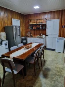 eine Küche mit einem großen Holztisch und Stühlen in der Unterkunft Casa Apuaú in Novo Airão