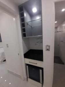 a white kitchen with a sink and a closet at Hermoso apartamento Residencial madera I in Santiago de los Caballeros