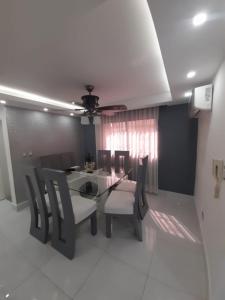 a dining room with a table and chairs and a ceiling at Hermoso apartamento Residencial madera I in Santiago de los Caballeros
