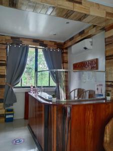 a bar in a room with wooden walls and a window at Woodland Inn in El Nido