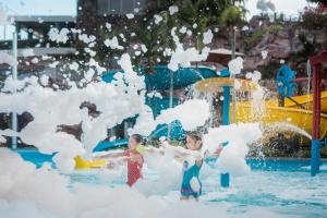 dos niños jugando en el agua en un parque acuático en Shangri-La Sanya en Sanya