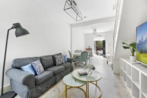 a living room with a couch and a table at WIND85P - Pet Friendly Paddo Terrace in Sydney