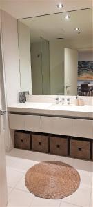 baño con lavabo y espejo grande en beautiful apartment 100mts near the beach in Port Melbourne, en Melbourne