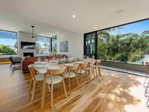 a dining room with a long table and chairs at Beachfront Escape - 6 bedroom, Pool & beach access in Merimbula