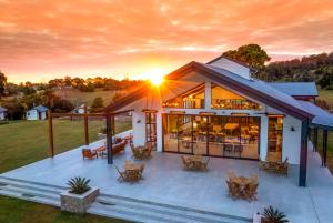 a house with a large deck with the sun setting at Beechmont Estate in Beechmont +49 photos