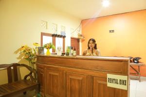 a woman sitting at a counter in front of a mirror at Orange Balangan Bungalow in Uluwatu