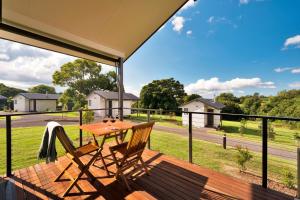 a wooden deck with a table and chairs on a balcony at Beechmont Estate in Beechmont