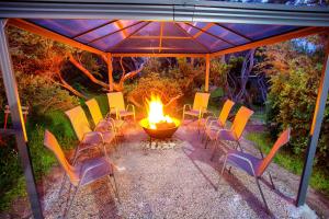 a group of chairs and a fire pit under a tent at Retro Dunes Venus Bay - WiFi, Netflix, BBQ, linens, pets OK in Venus Bay