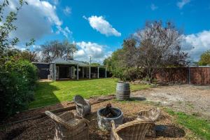 a yard with chairs and a house at 'Mudgee Maison' A Charming Vintage Country Escape in Mudgee