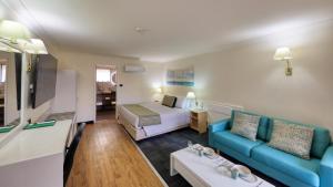 a hotel room with a bed and a couch at The Palms Dubbo in Dubbo