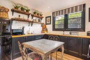 a kitchen with a table and chairs in it at 'Mudgee Maison' A Charming Vintage Country Escape in Mudgee