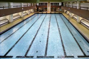 una piscina vacía en un gimnasio con agua azul en AXA Hotel en Praga