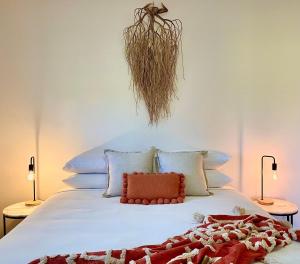 a bedroom with a large white bed with two lamps at Emma's Cottage Vineyard in Lovedale