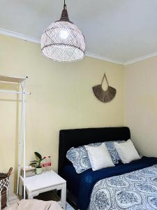 a bedroom with a bed and a pendant light at Omah Kebon Kalasan in Sleman