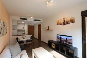 a living room with a white couch and a tv at Aguilas Residencial El Cedro BIF2 in Águilas