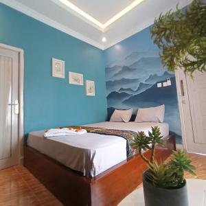 2 letti in una camera con parete blu di Lontart Guesthouse a Nggorang
