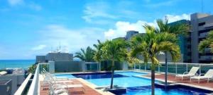a swimming pool on the roof of a building with palm trees at Apartamento na praia de Jatiúca com piscina e área de lazer in Maceió +24 photos