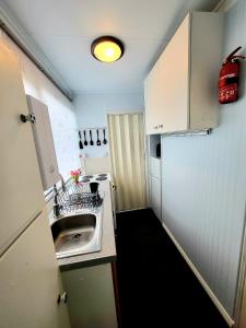 a small kitchen with a sink and white cabinets at Holiday Chalet no289 in Withernsea