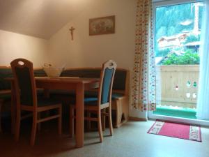 ein Esszimmer mit einem Tisch, Stühlen und einem Fenster in der Unterkunft Haus Toferer in Großarl
